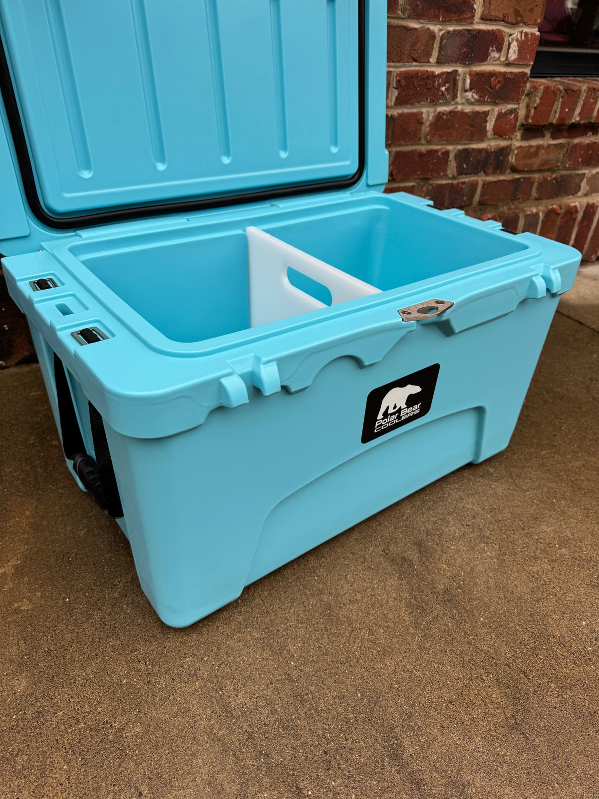 Light blue hard cooler with open lid and drain plug detail