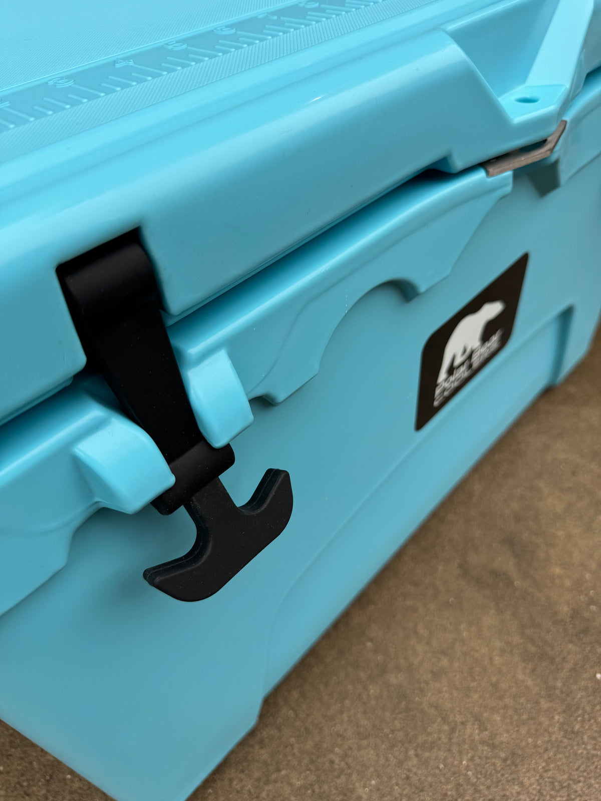 Caribbean blue hard cooler side latches and handle near Polar Bear Coolers logo