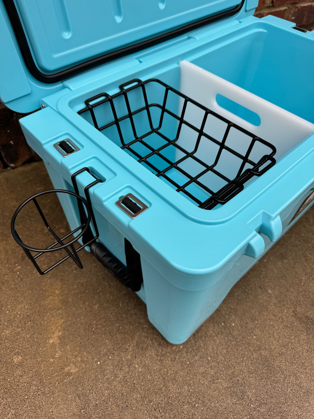 Light blue hard cooler with open basket-style divider and front latch knobs