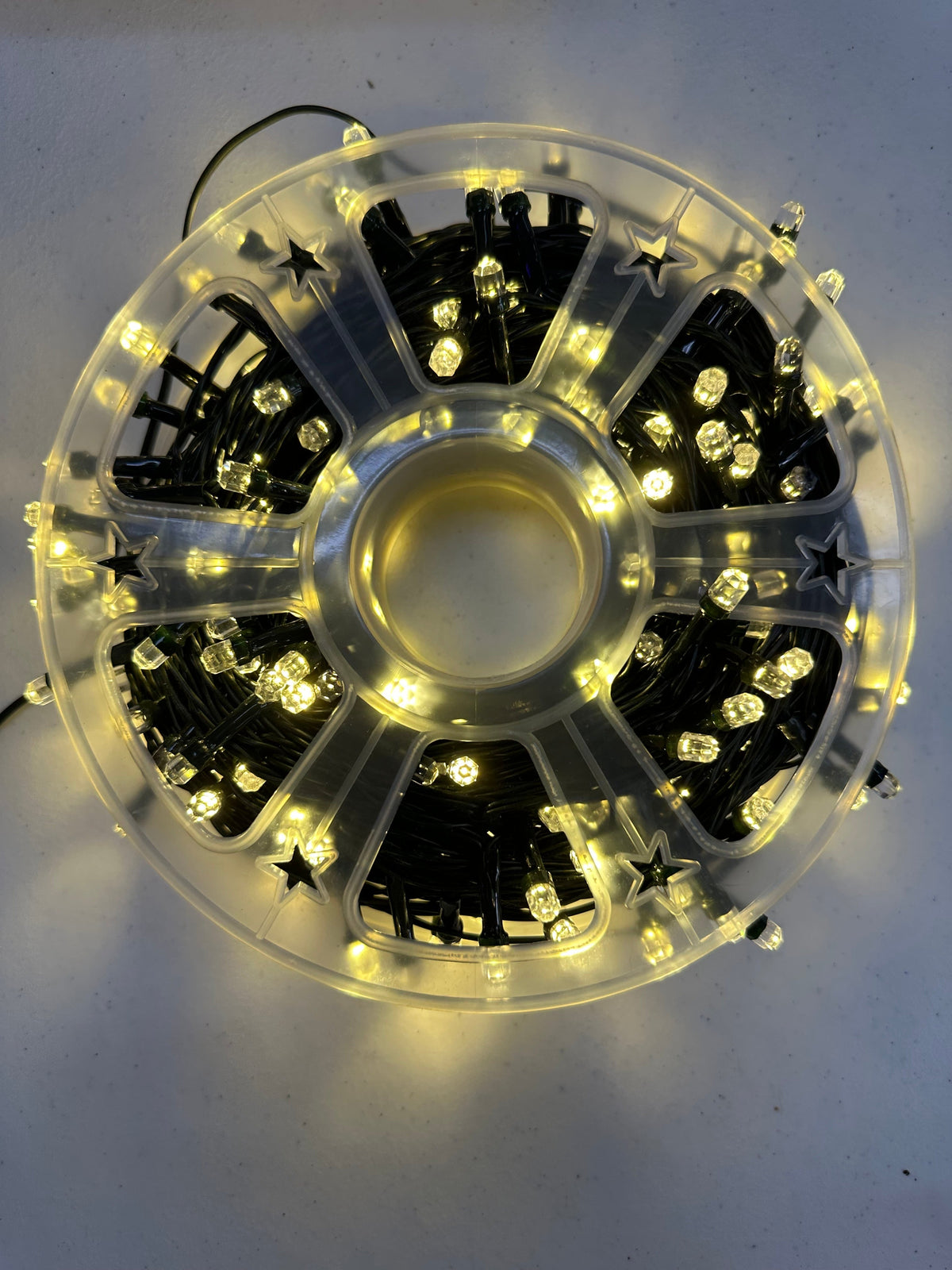 Lit 300 LED string light roll with warm white glow and black bulb holders