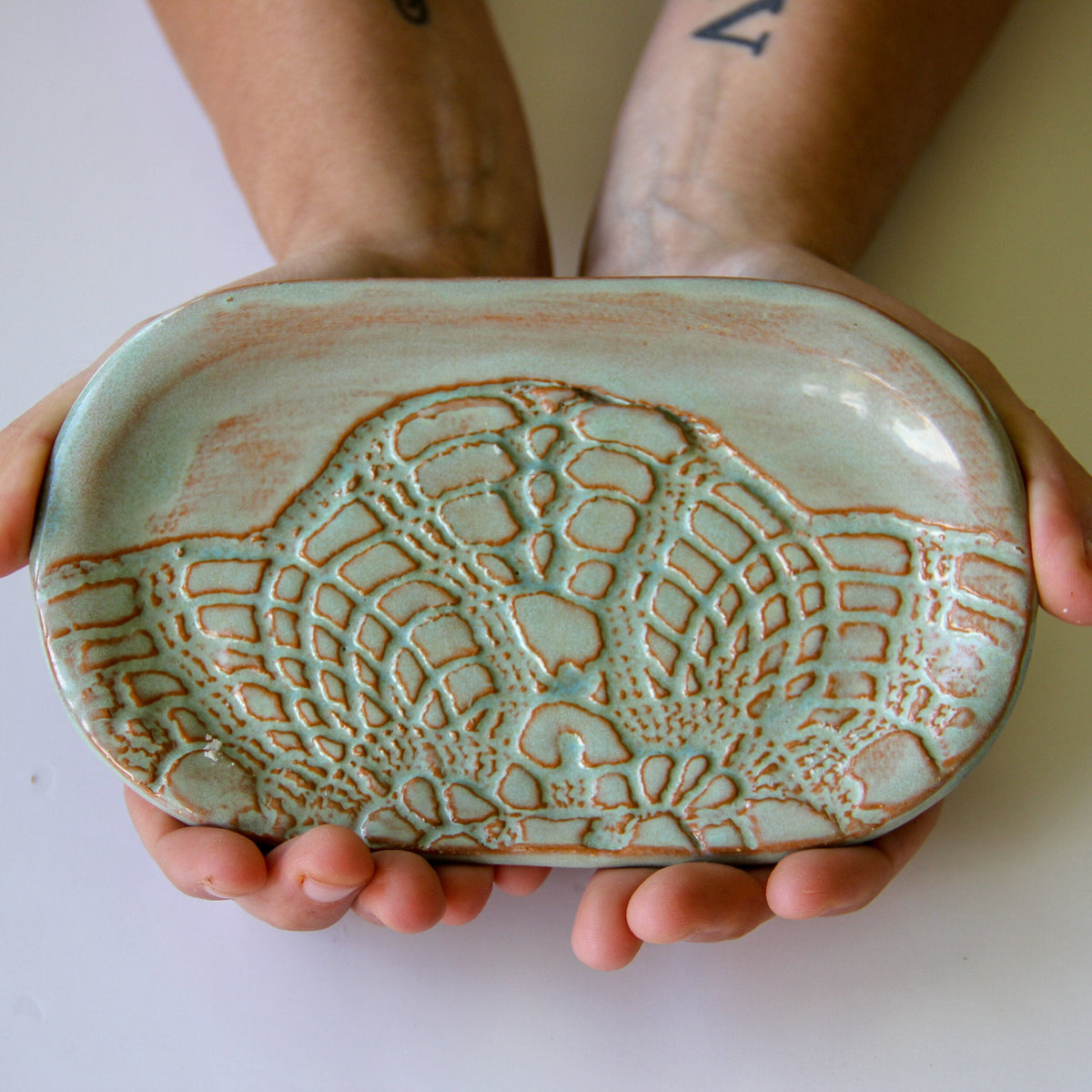 Ceramic soap dish with textured leaf pattern, pale green and amber speckled glaze