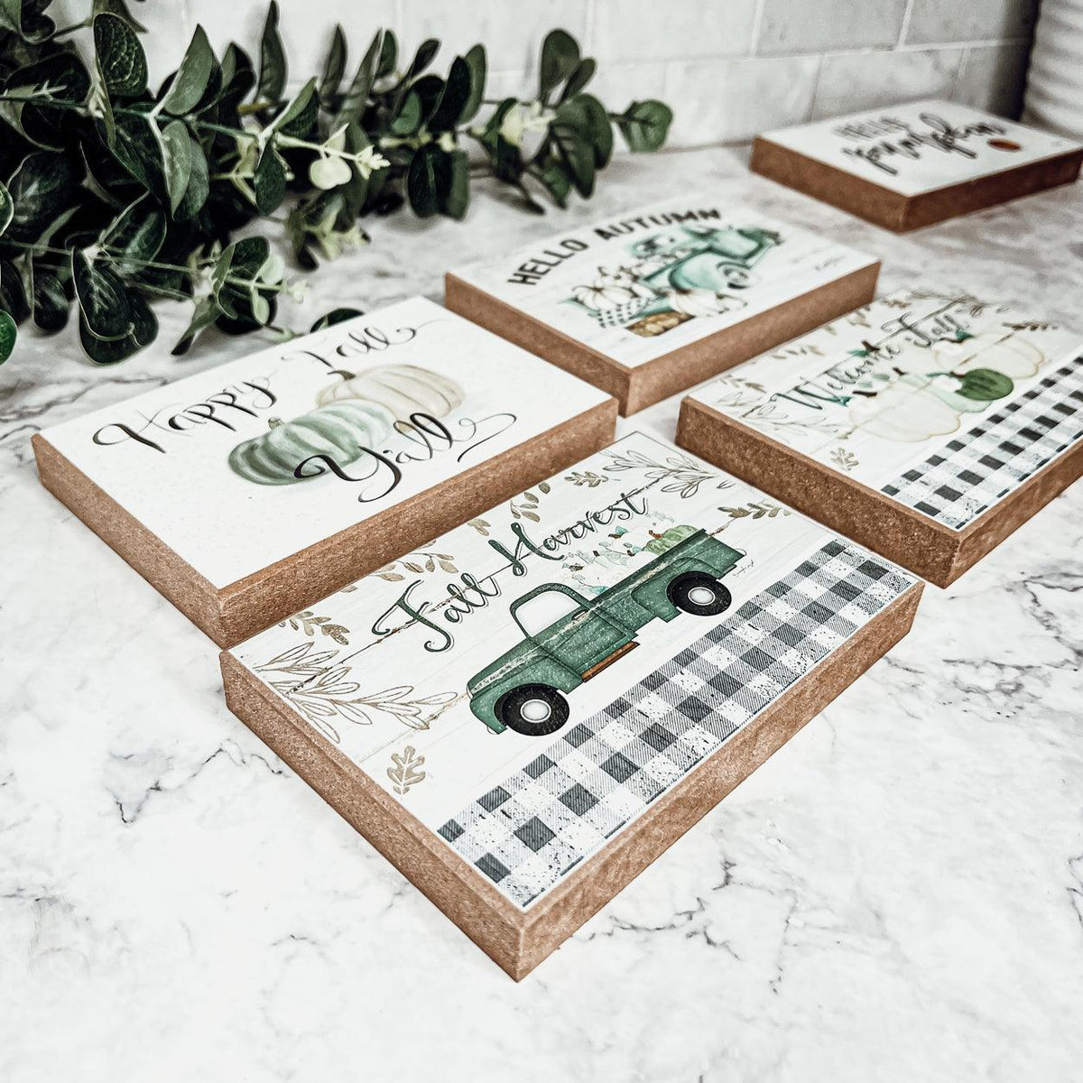 Five fall greeting cards on stone surface with pumpkins and green truck scenes