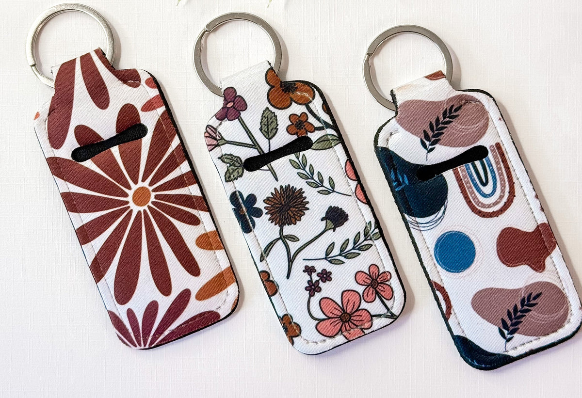 Chapstick holder keychains with botanical and circle patterns, three metal key rings