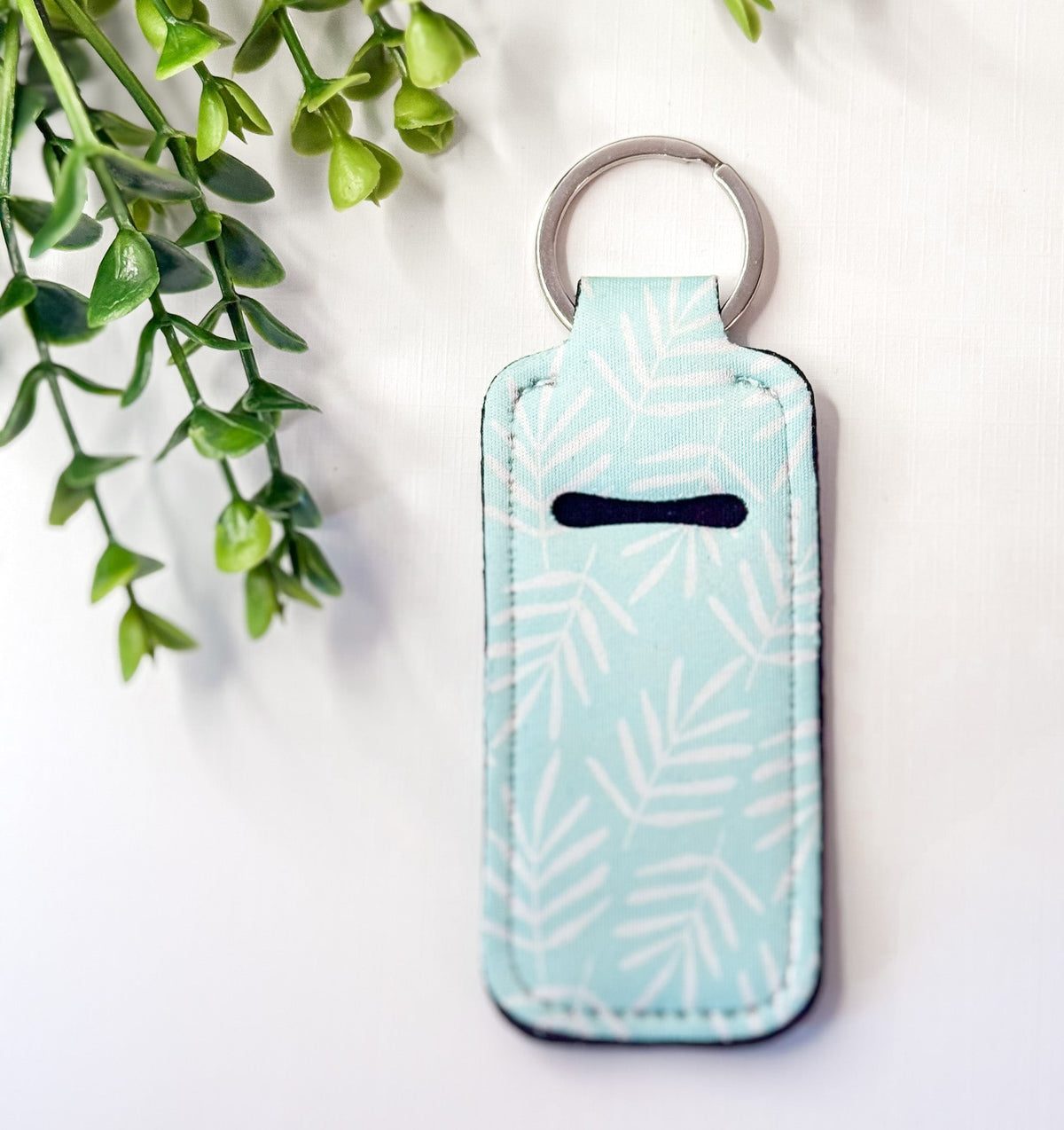 Chapstick holder keychain with light blue leaf pattern, silver key ring