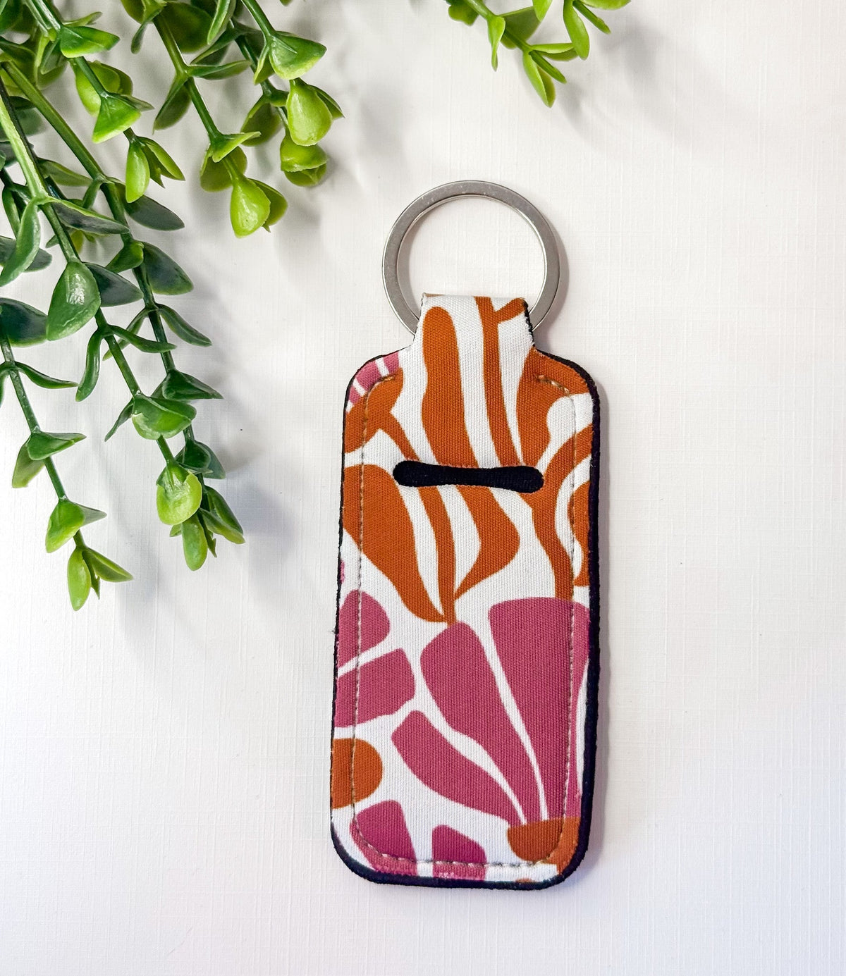 Chapstick holder keychain with orange and pink abstract stripe print, silver key ring