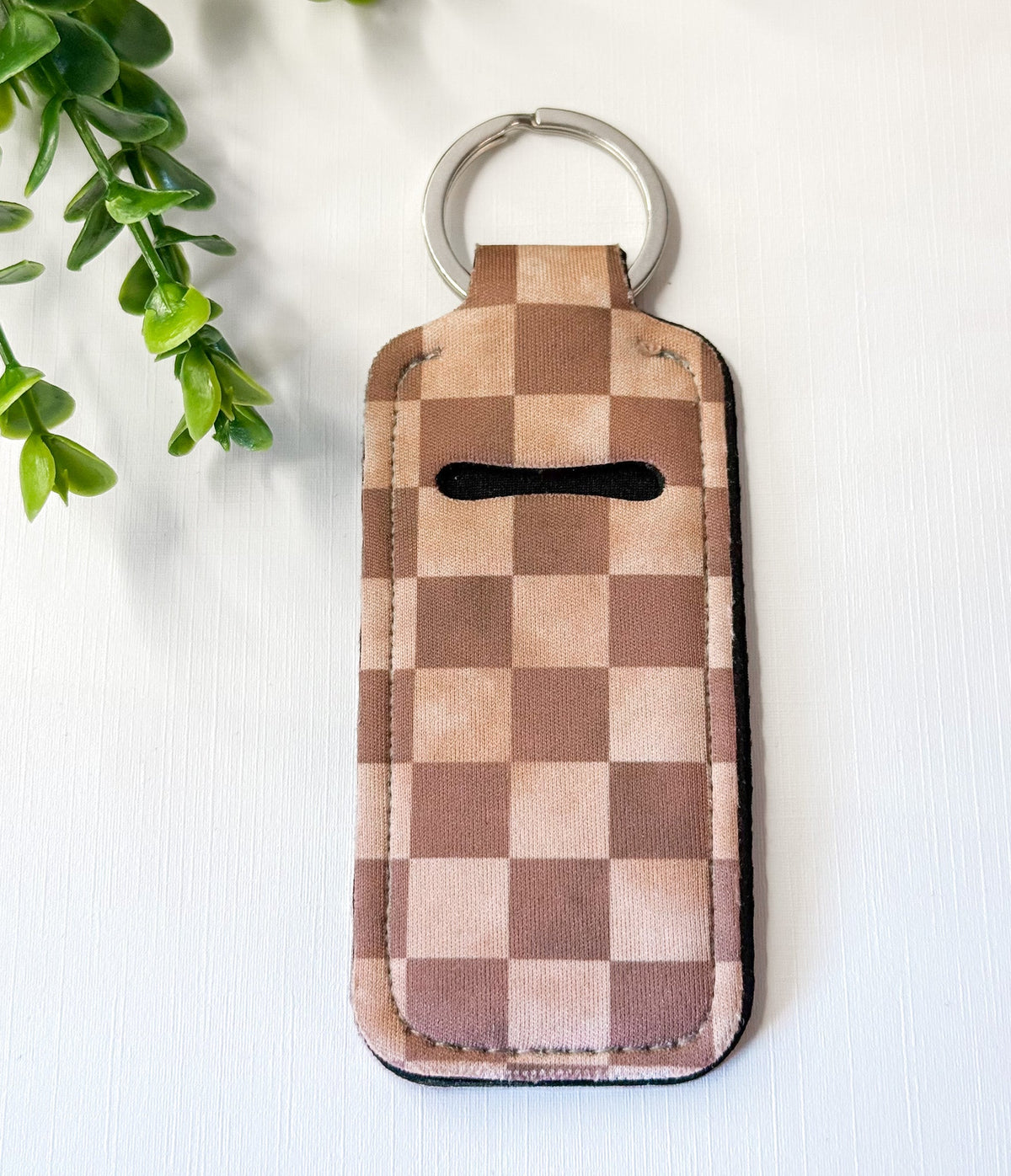 Chapstick holder keychain with brown checkerboard pattern, silver key ring