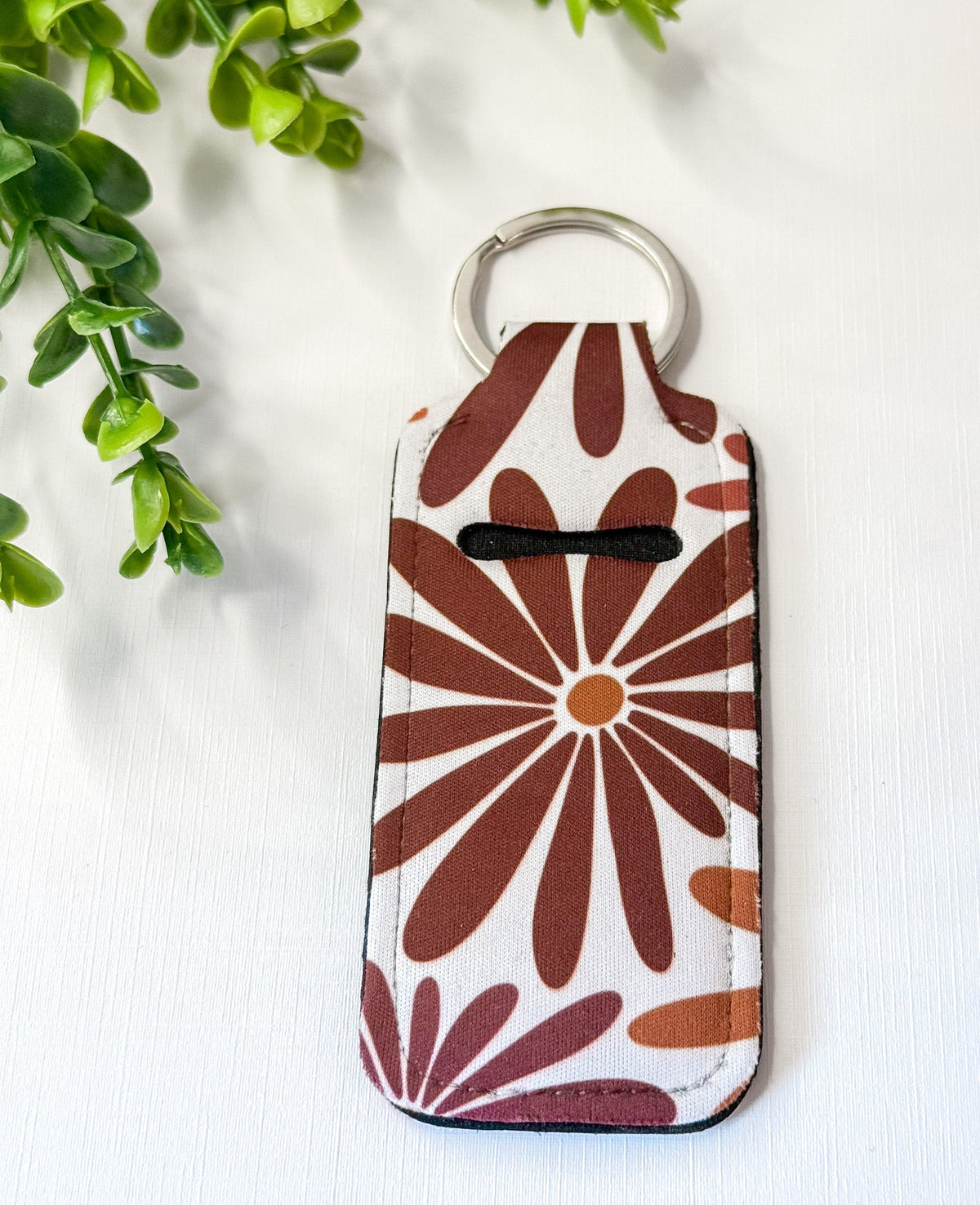 Chapstick holder keychain with brown daisy burst print, silver key ring