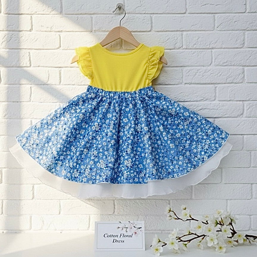 Yellow yoke toddler dress with blue floral skirt and scalloped white ruffle hem
