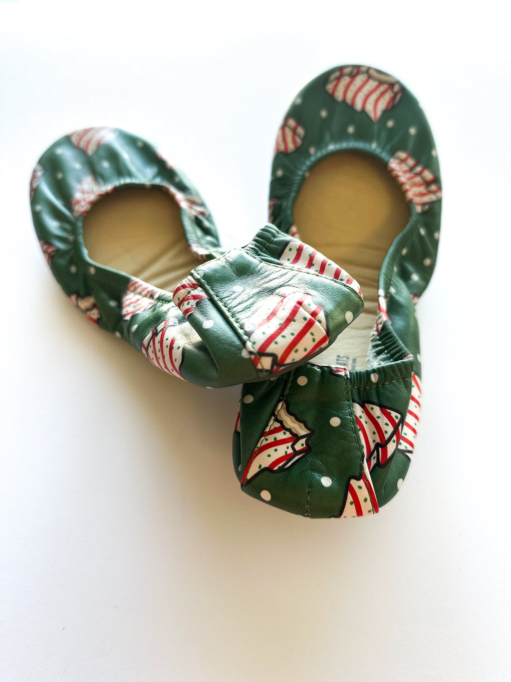 Green candy cane patterned slip-on shoes, open toe, stacked at an angle