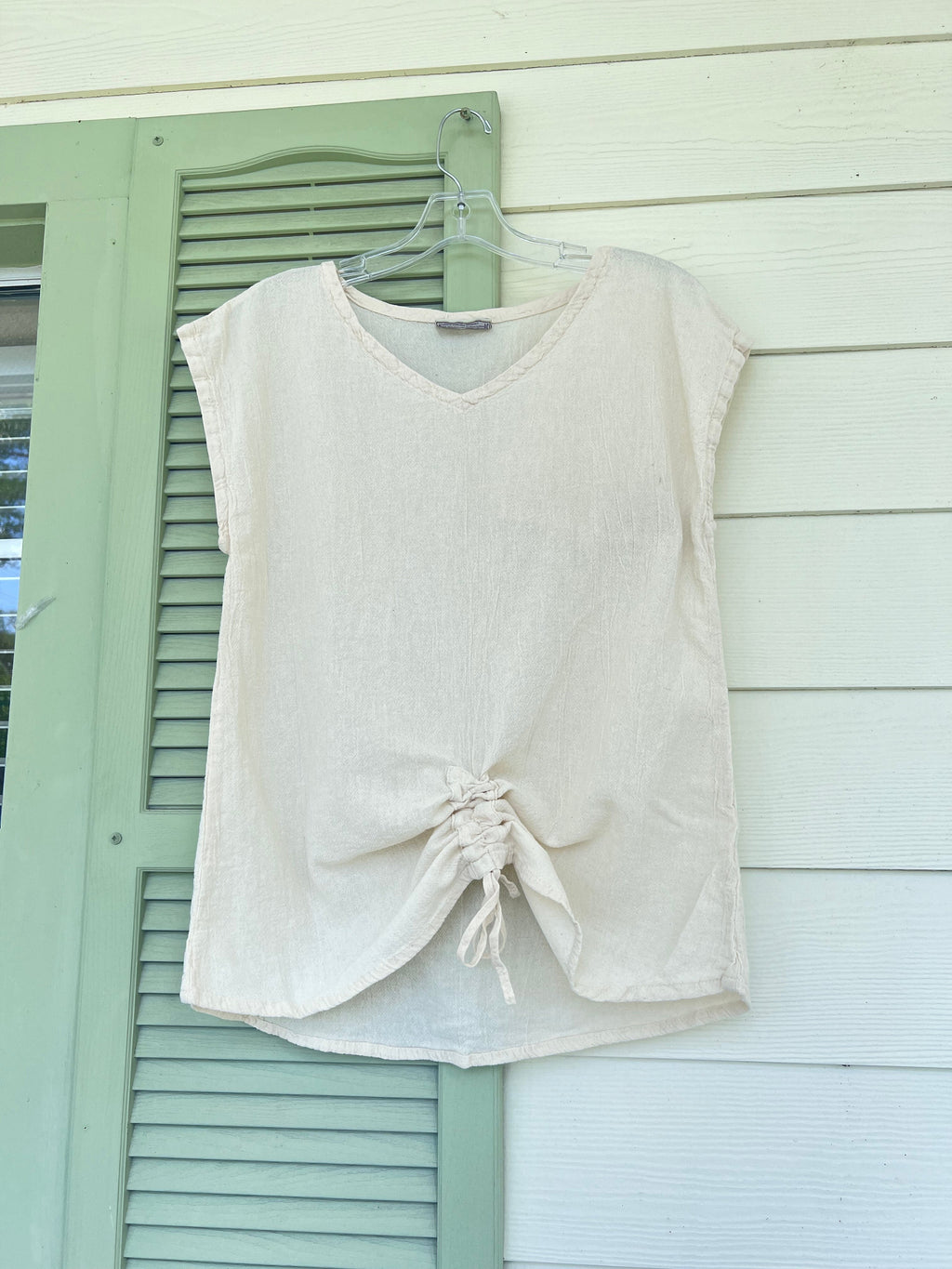 White cotton gauze camie top on hanger with scoop neck and front ruched tie.