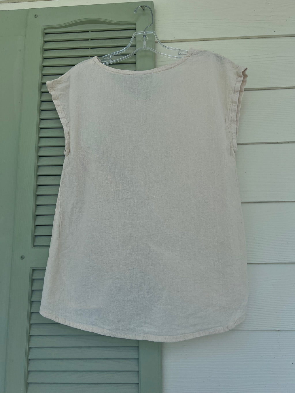 White cotton gauze camie top on hanger with scoop neck and short sleeves.