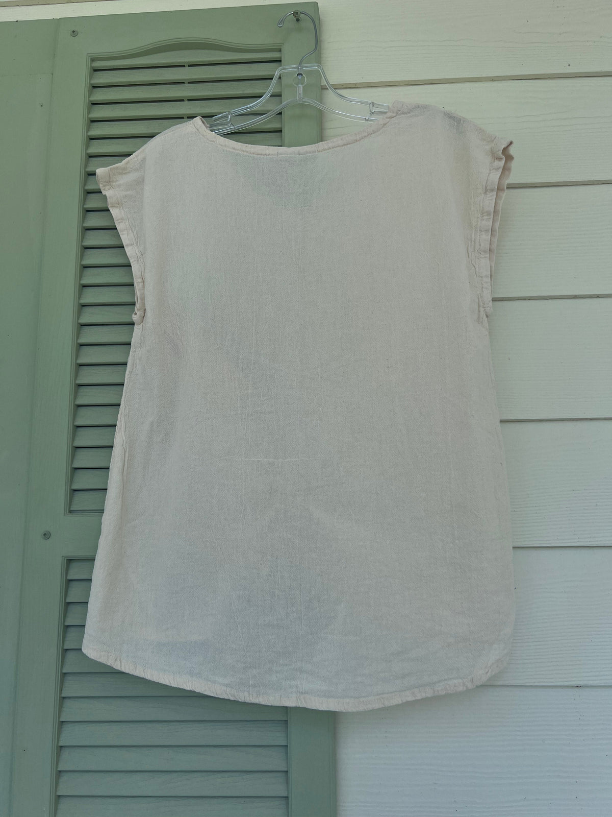 White cotton gauze camie top on hanger with scoop neck and short sleeves.