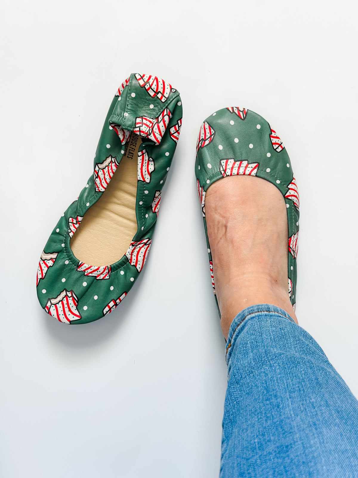 Pair of green candy cane patterned slip-on flats with open toe