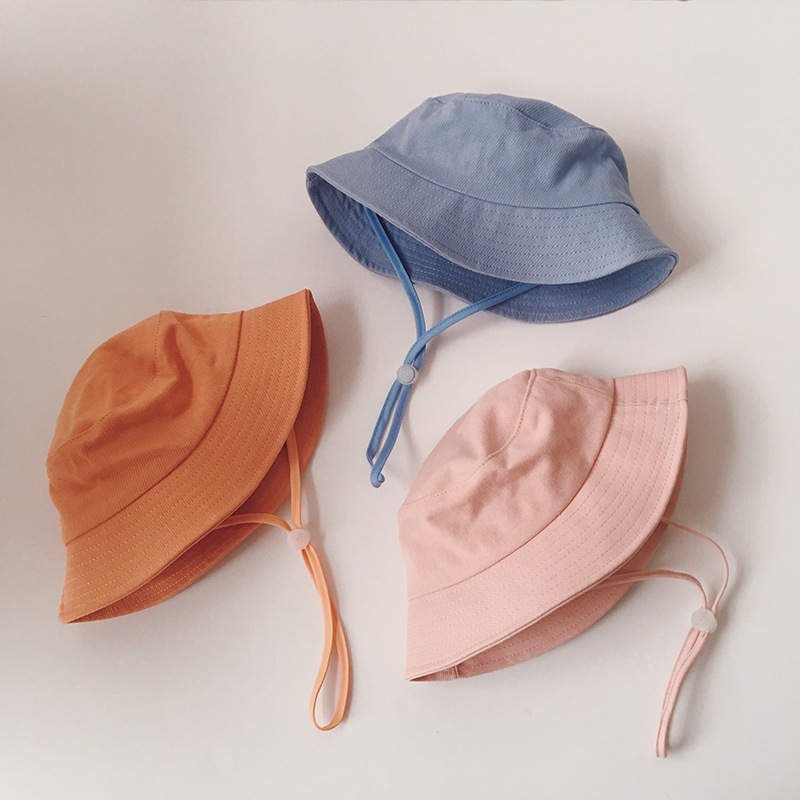 Assorted kids linen fisherman bucket hats in orange, blue, and pink, with chin straps