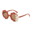 Red flower-shaped kids sunglasses with brown lenses and white daisy accents