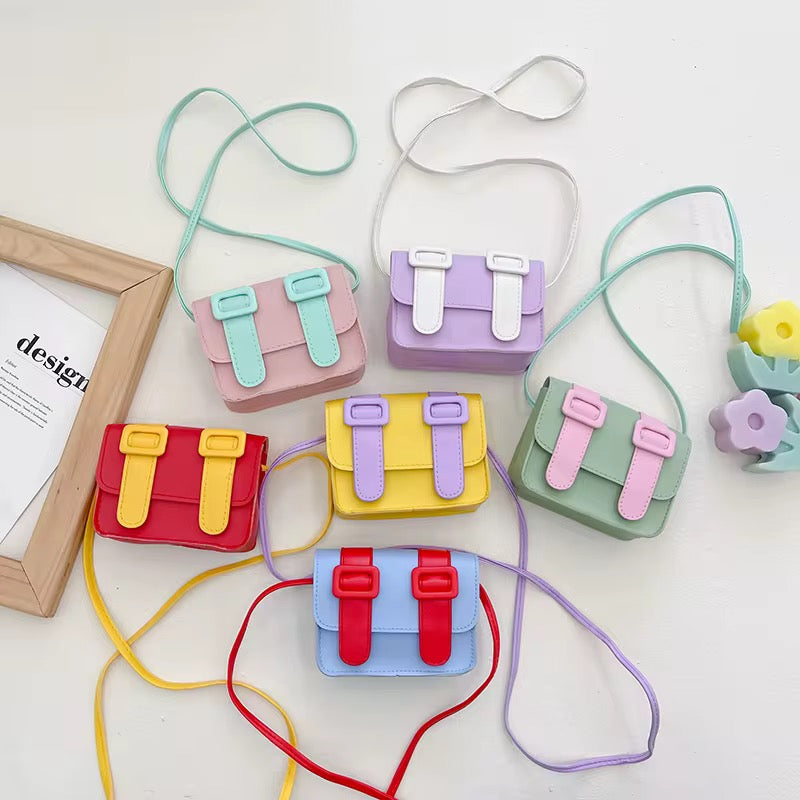 Kids mini color pop satchel bag assortment with adjustable crossbody cords and buckle fronts.