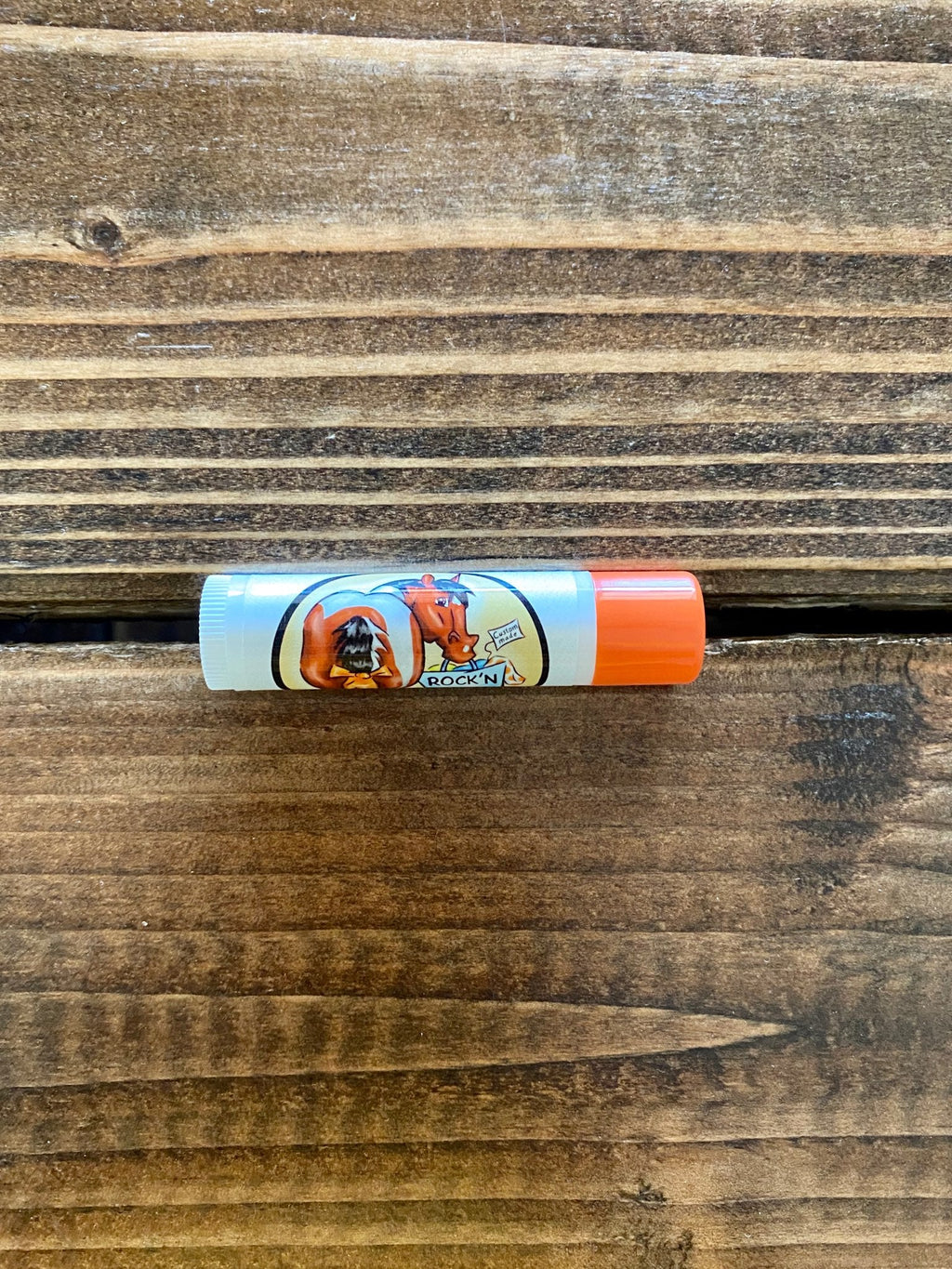 Chap-stick lip balm stick with orange cap and cartoon label