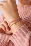 Bead stretch bracelet set with gold-tone charm and pink-and-gold bead strands