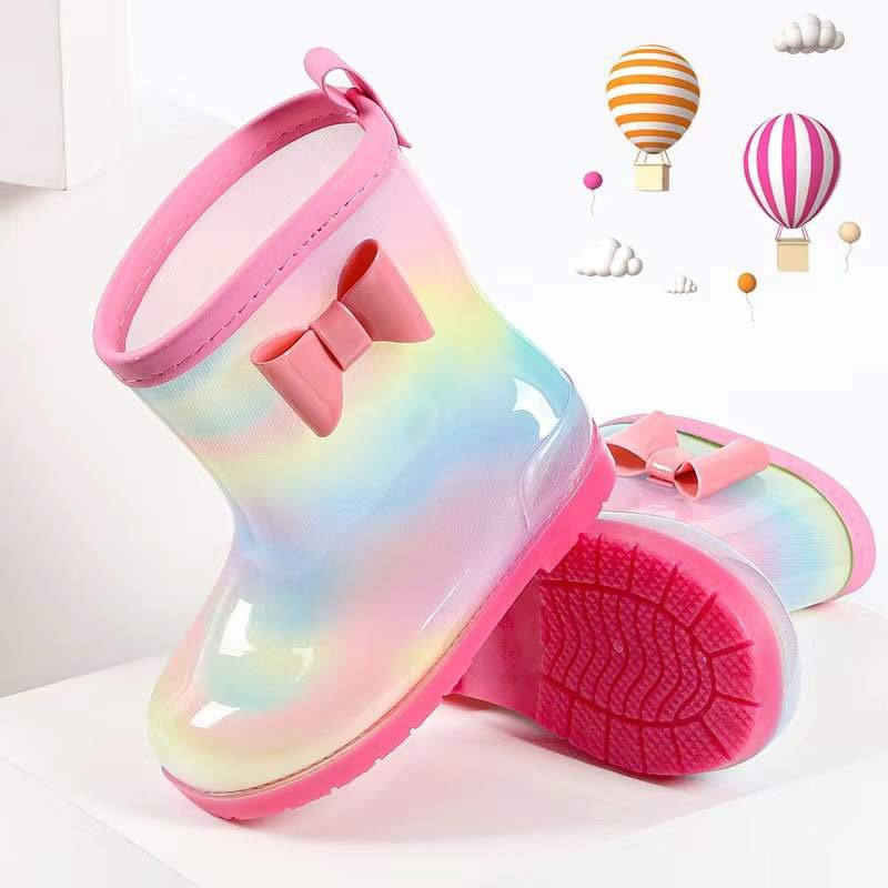 Kids rainbow waterproof rain boots with pink bow and visible tread sole