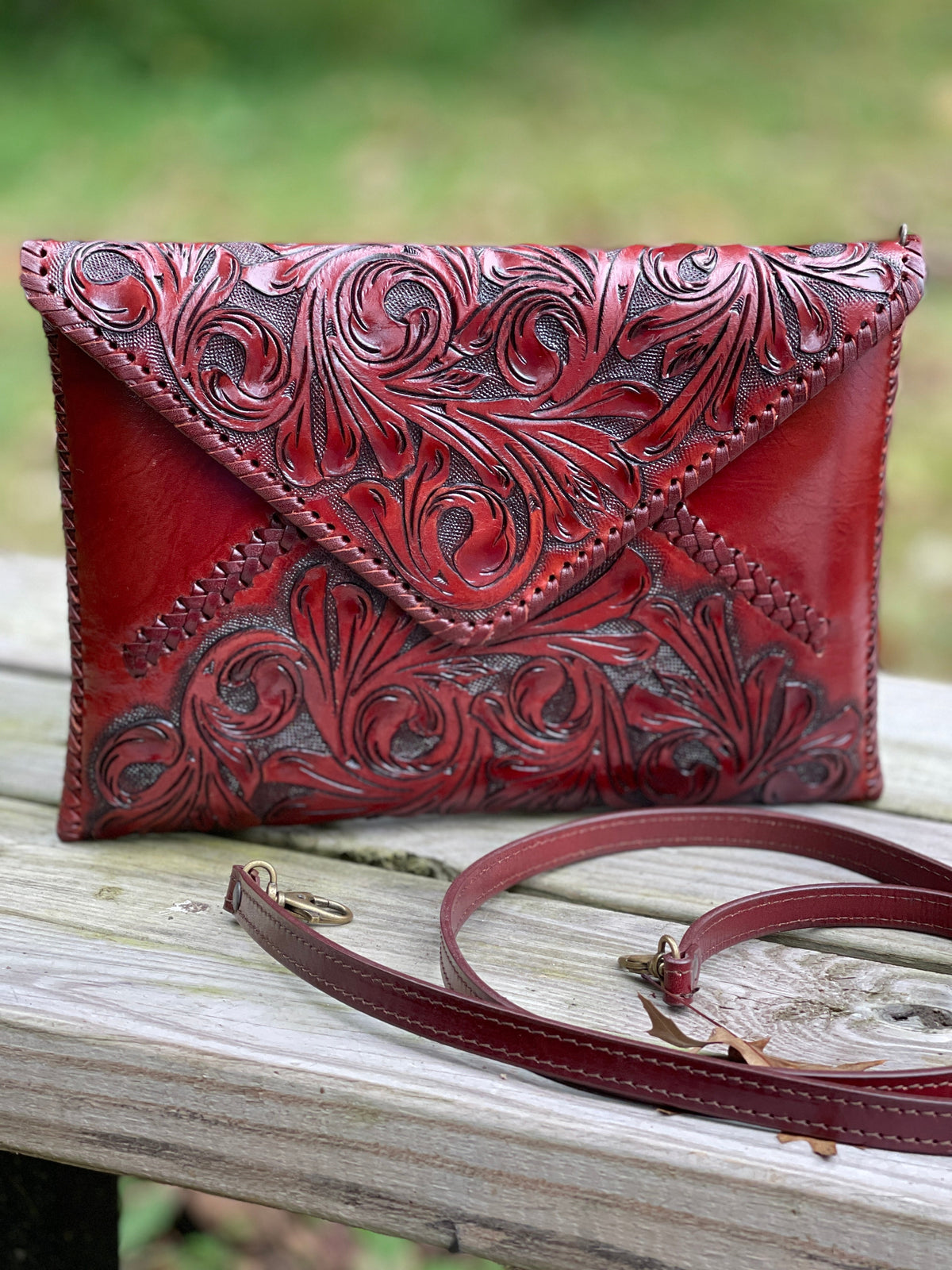 Hand-tooled leather crossbody clutch bag, maroon leather with carved floral top and strap