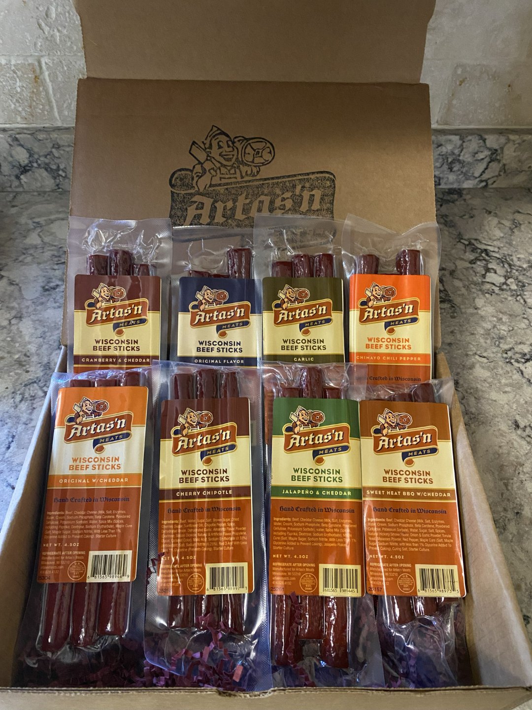 Artas'n Eight beef stick variety pack in clear bags inside a cardboard box
