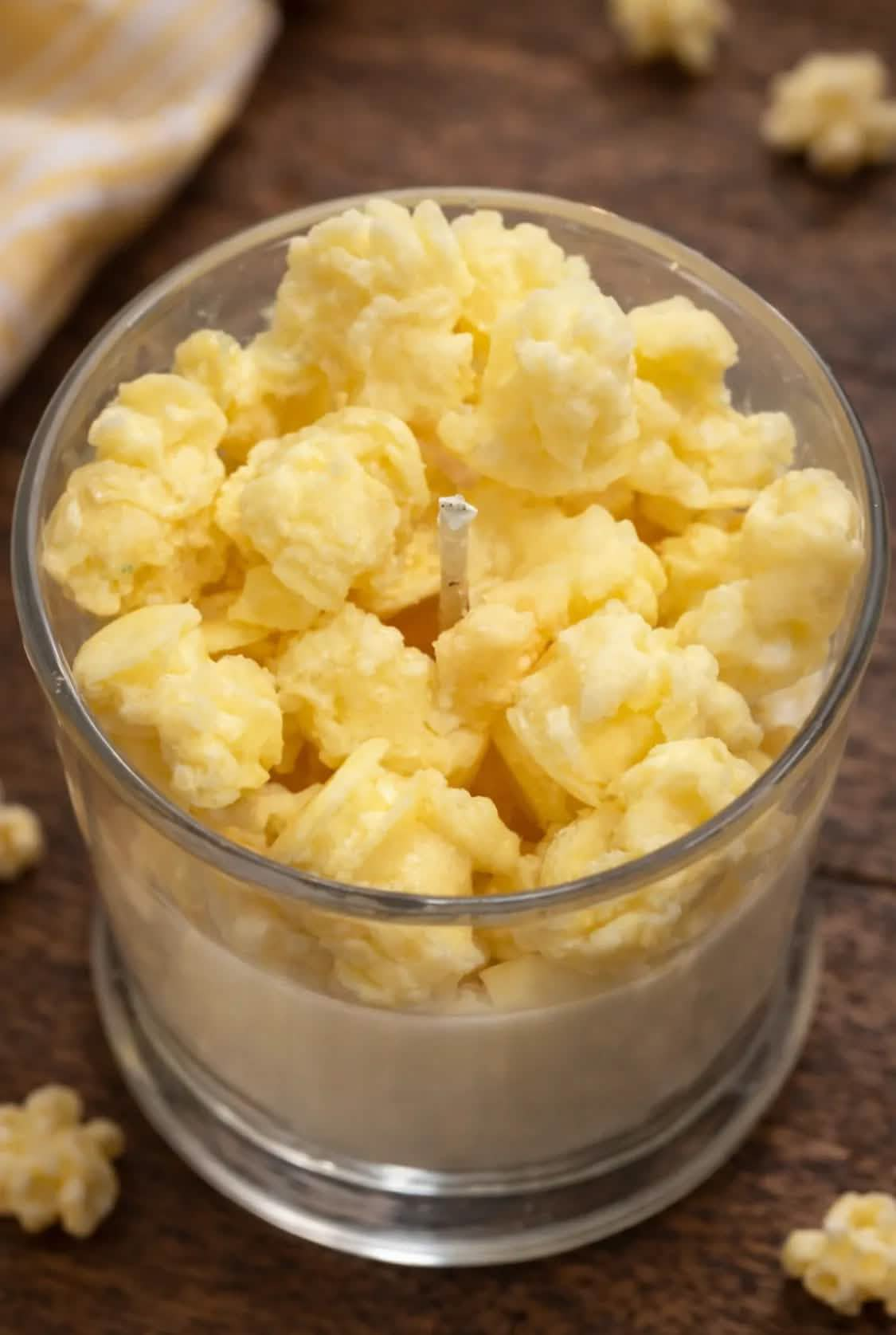 Top view of popcorn-style yellow wax chunks in a clear glass candle jar