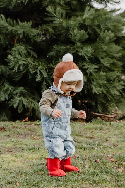 Kids faux fur trapper hat with white sherpa lining and pom-pom, brown suede color