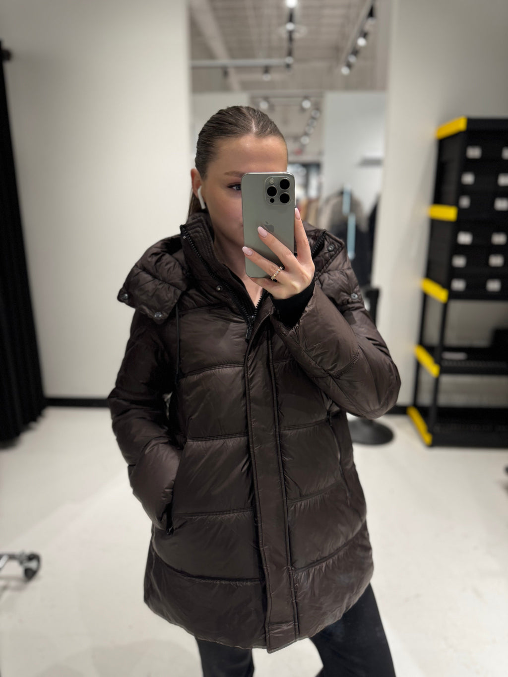 Chocolate hooded down-style puffer jacket on model, zip front and side pockets