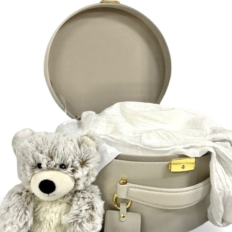 Gray round keepsake box with padded lid, gold clasp, and plush teddy tucked inside