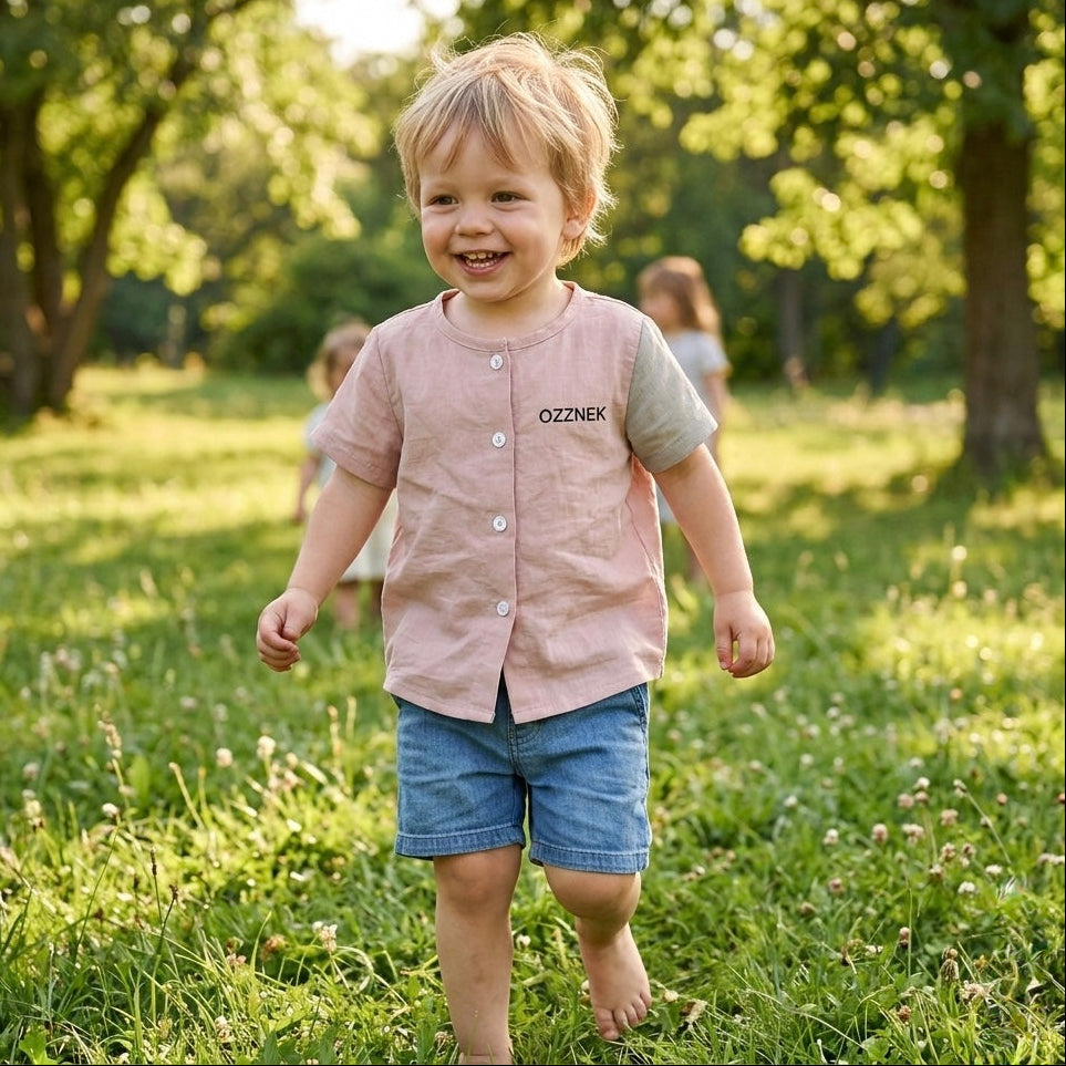 Toddler button-up shirt in light oatmeal pink, short sleeves with front buttons on child