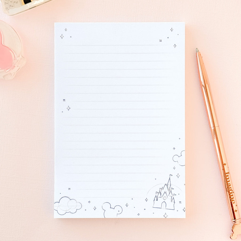 White sketch memo notepad with blue line icons, clouds, and mountain doodles on cover