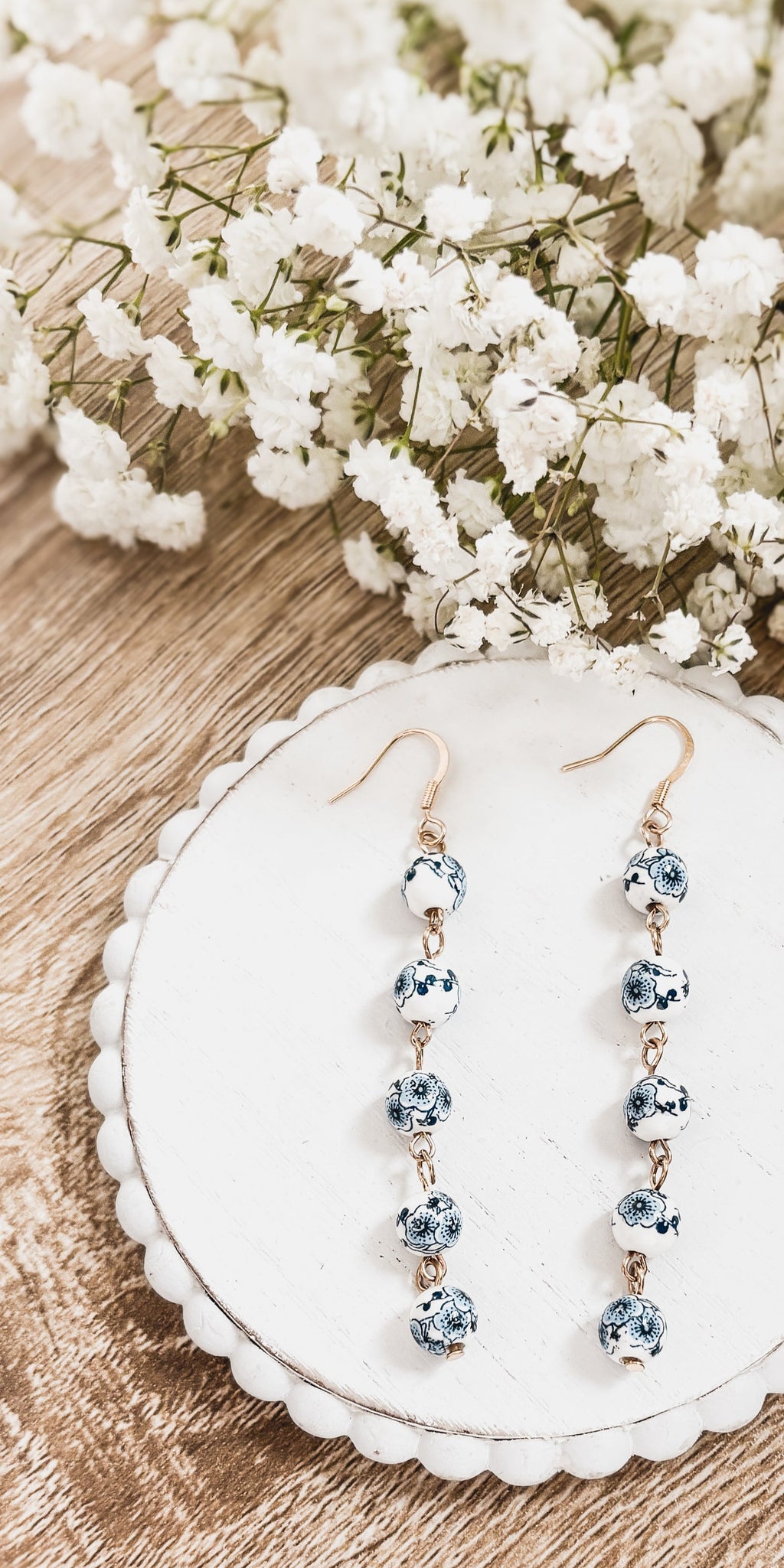 Porcelain drop earrings with blue patterned round charms and gold-tone fishhook backs