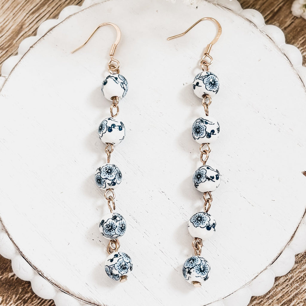 Porcelain drop earrings with blue-and-white round bead segments and gold-tone hooks