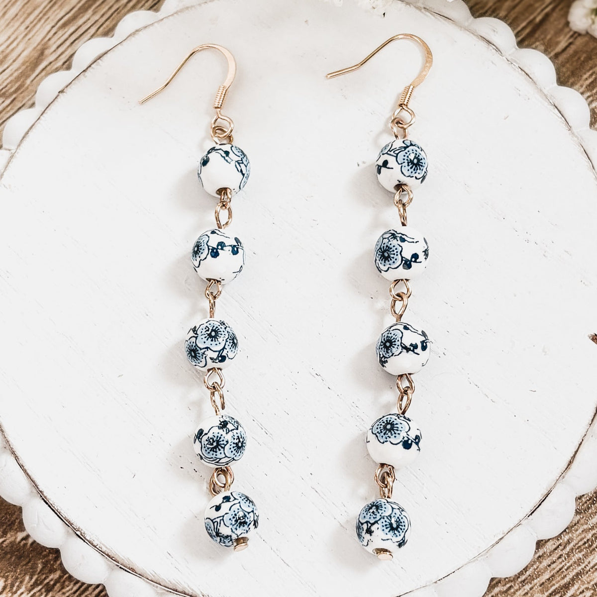 Porcelain drop earrings with blue-and-white round bead segments and gold-tone hooks