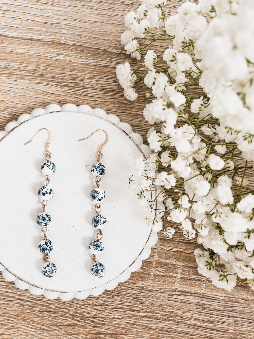 Blue porcelain bead drop earrings with gold-tone hooks, dangling five beads each