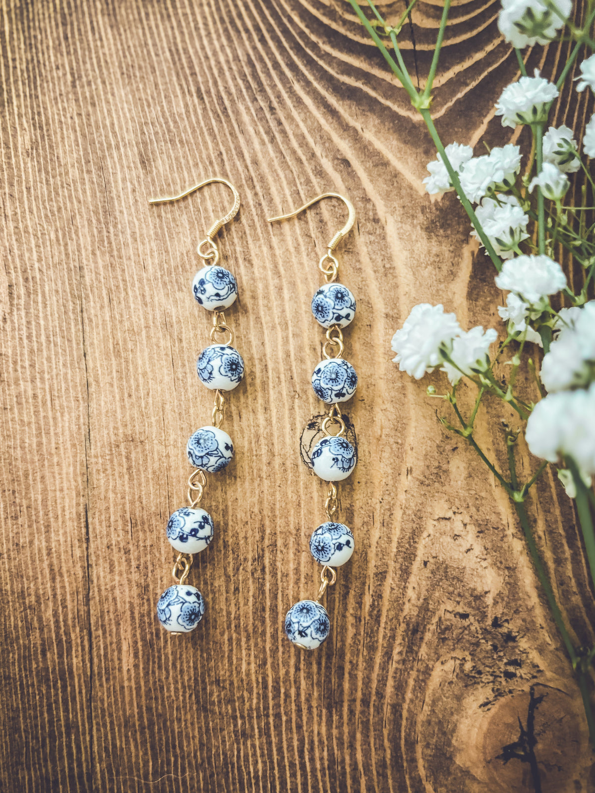 Blue porcelain bead drop earrings with gold-tone hooks; long dangling bead chain