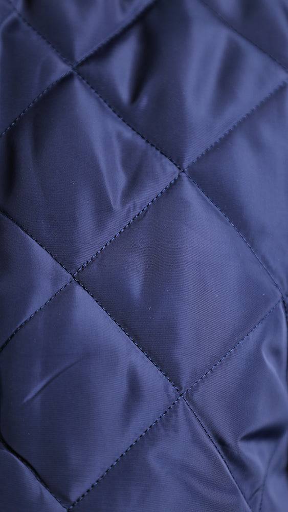 Navy quilted diamond-pattern bomber jacket fabric texture close-up