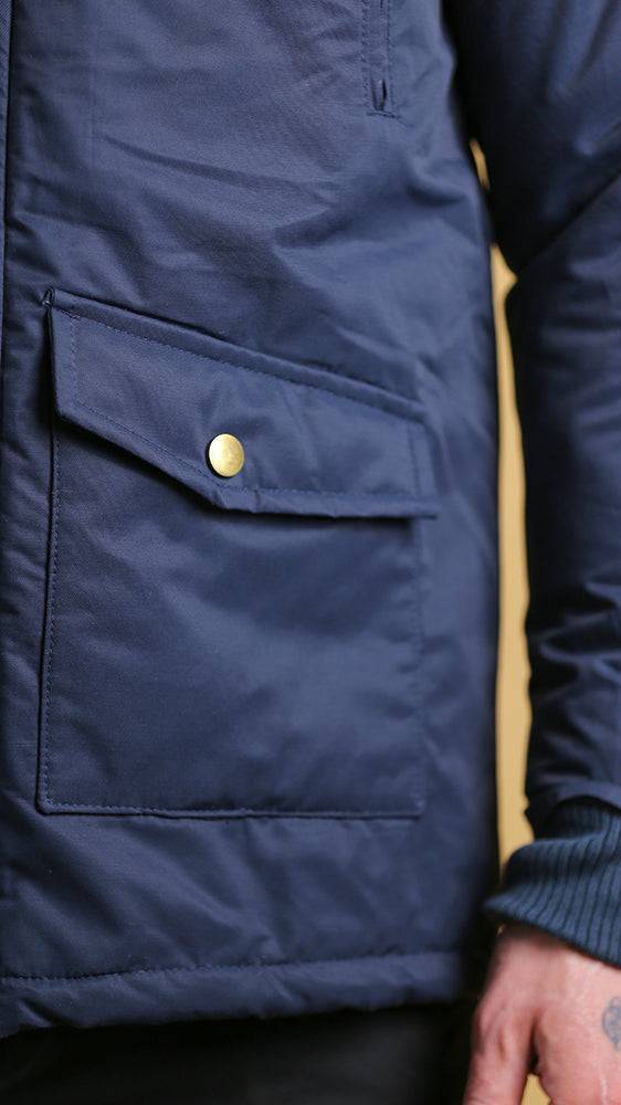 Navy utility pocket detail with gold snap on bomber jacket