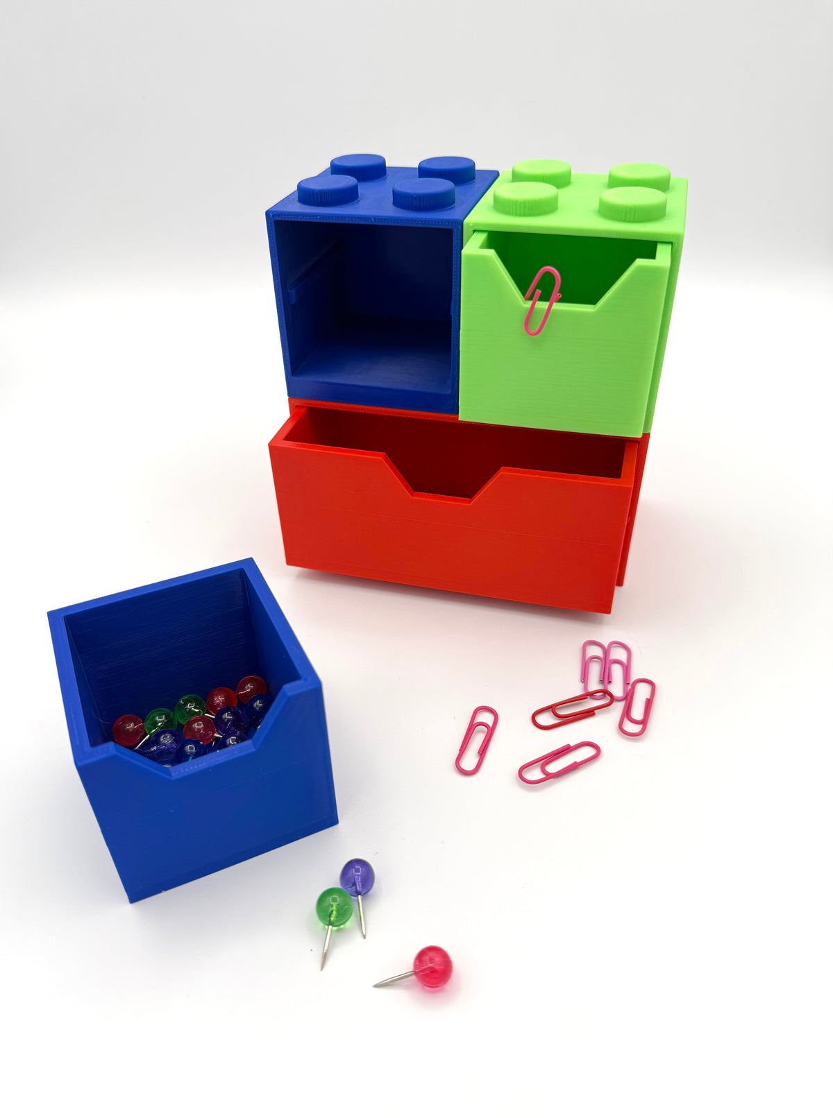 Block-style desk organizer with blue, green, red drawers; includes small bin and clips