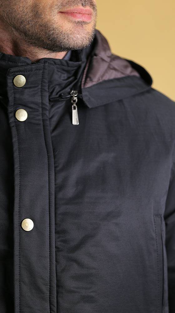 Black hooded bomber jacket close-up with snap buttons and center zipper