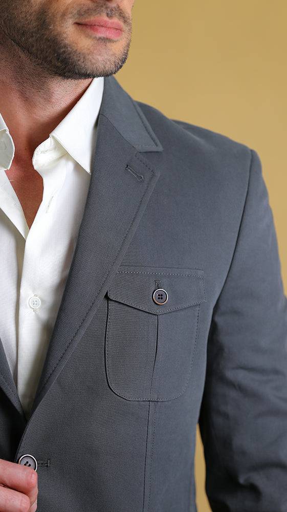 Dark asphalt blue-gray bespoke blazer close-up: notch lapel, chest welt pocket, button detail