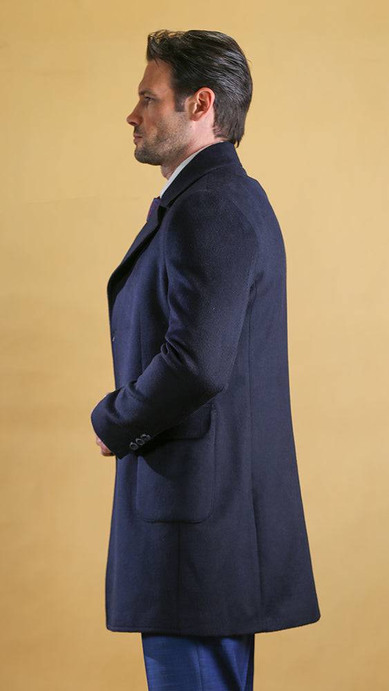 Men's navy overcoat side view with notched collar and button closure.