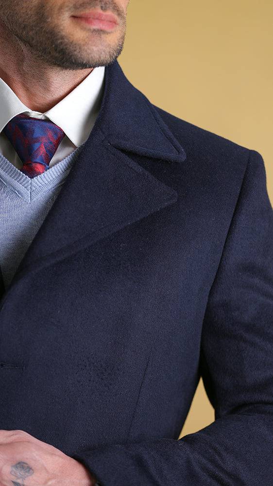 Navy overcoat lapel and chest pocket detail with buttons.