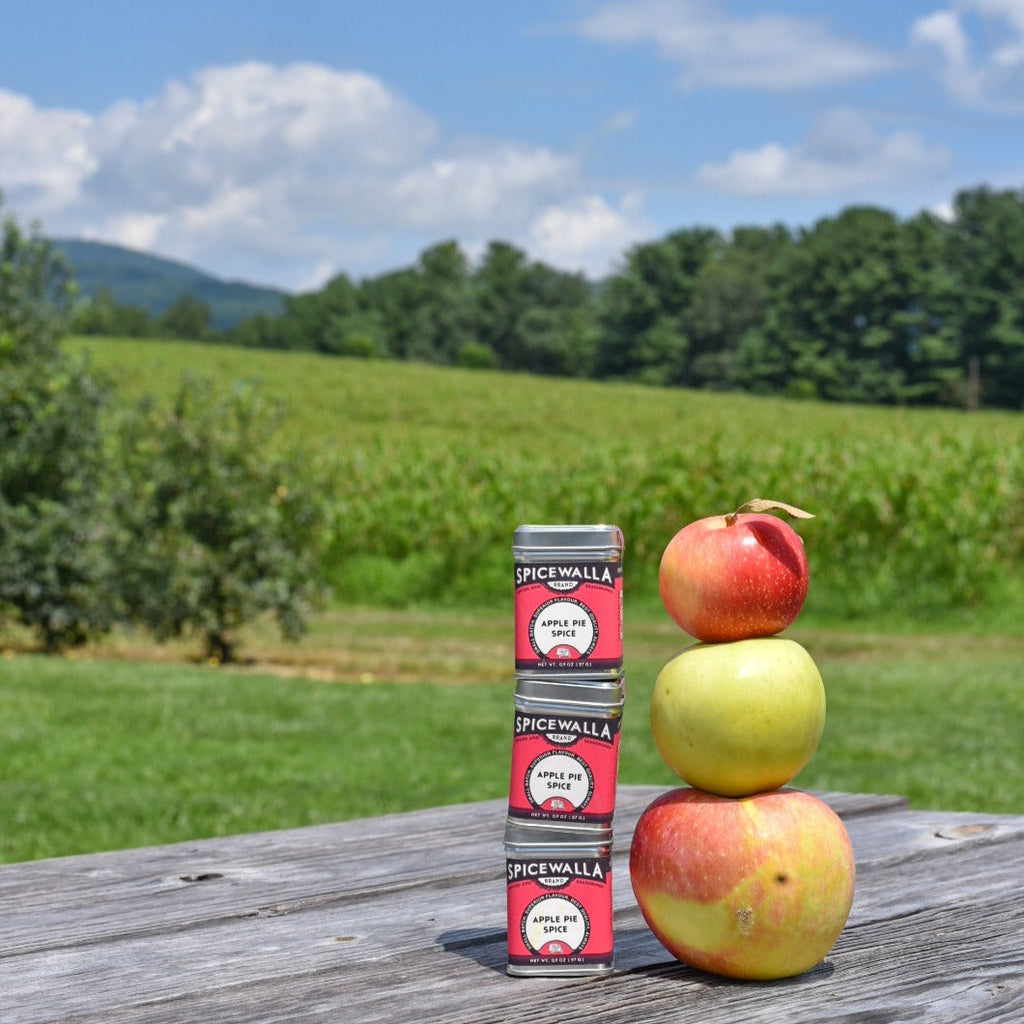 Spicewalla Apple Pie Spice tin standing with apples on a wooden table