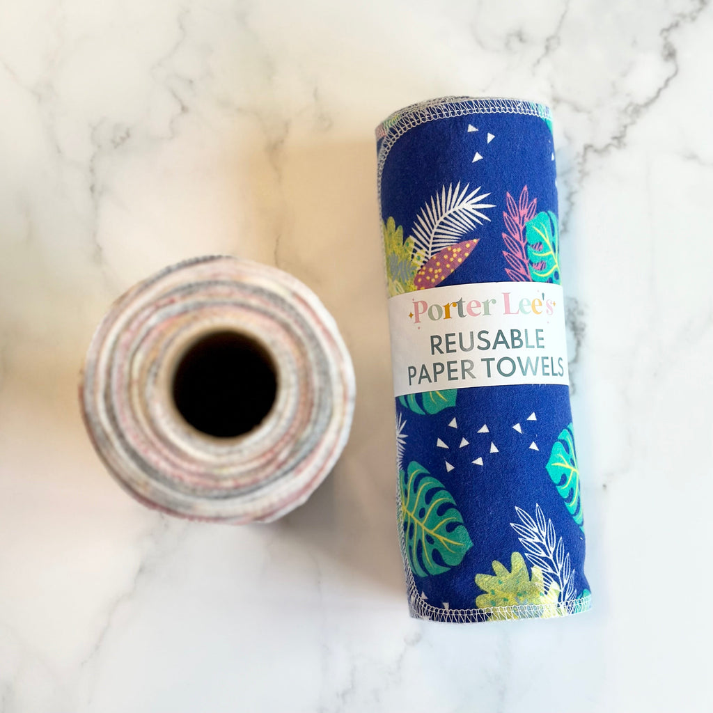 Reusable paper towel roll in navy with tropical leaves and palm prints, plus loose roll