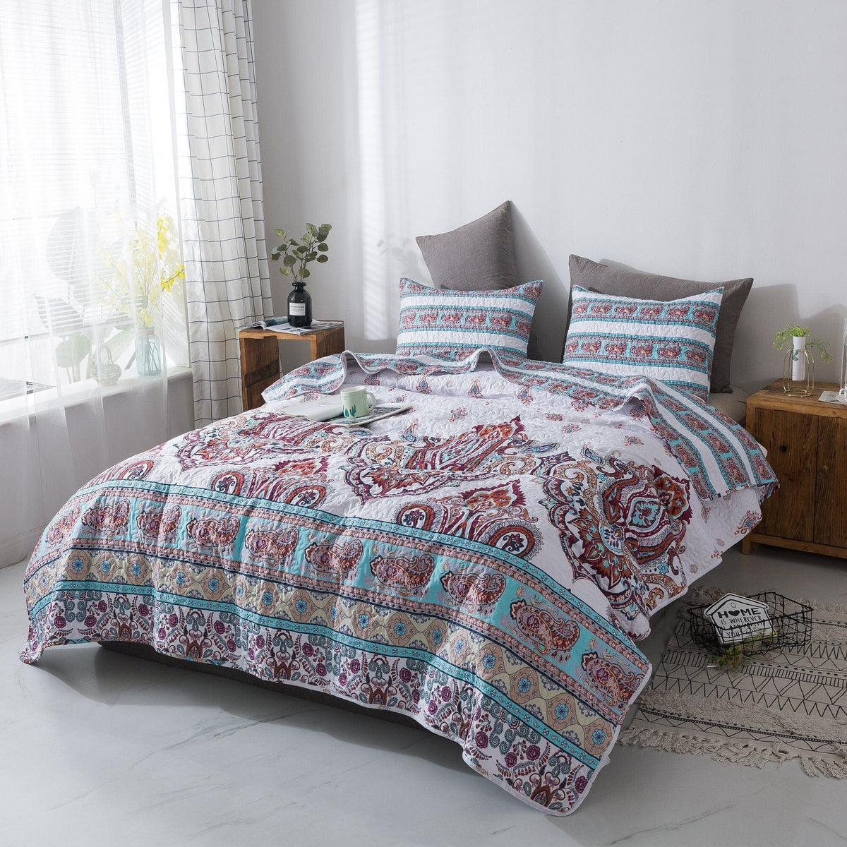 White paisley quilt set with blue border and red-burgundy motifs, styled with two shams