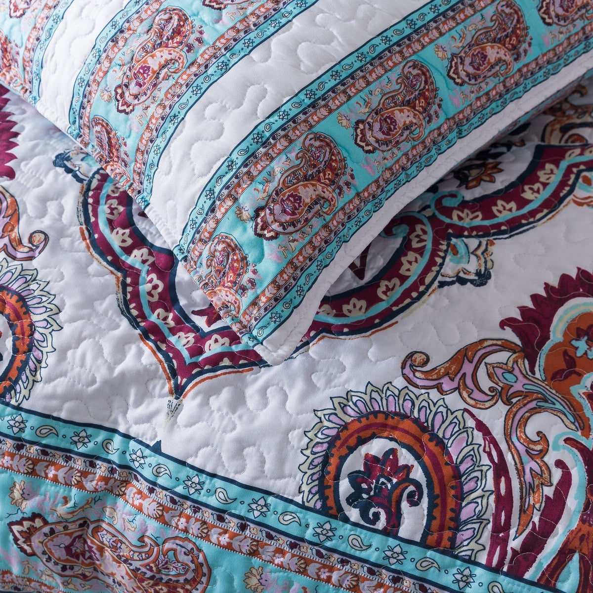 Blue, white, and red paisley quilt with stitched quilting and matching pillow