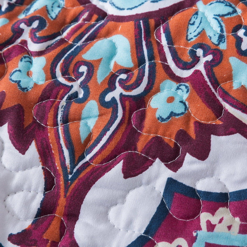 Close-up of multicolor paisley quilt fabric with textured stitched quilting