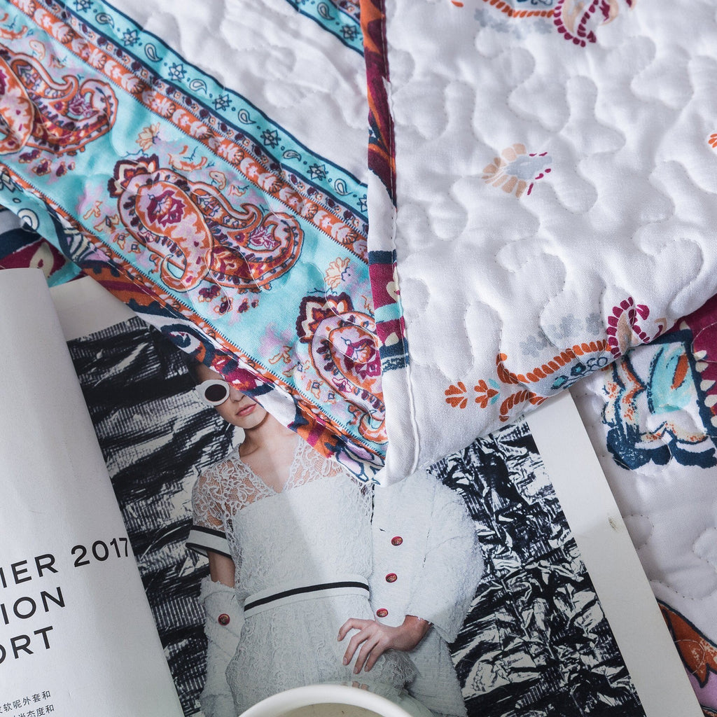 Quilt corner with stitched texture and paisley print on white fabric