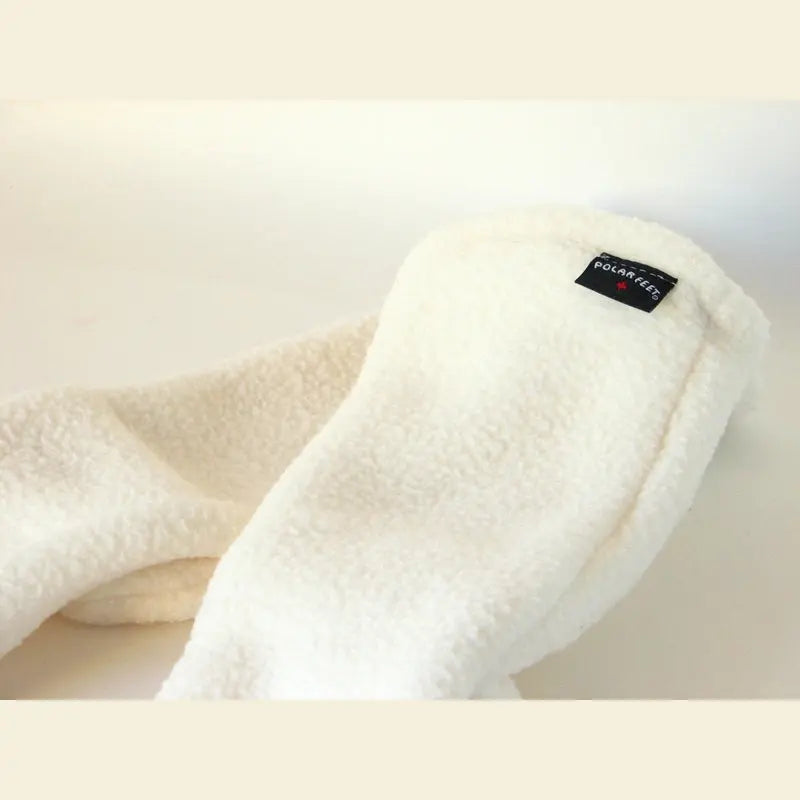 Cream fleece sock with black logo patch near ankle, soft textured fabric